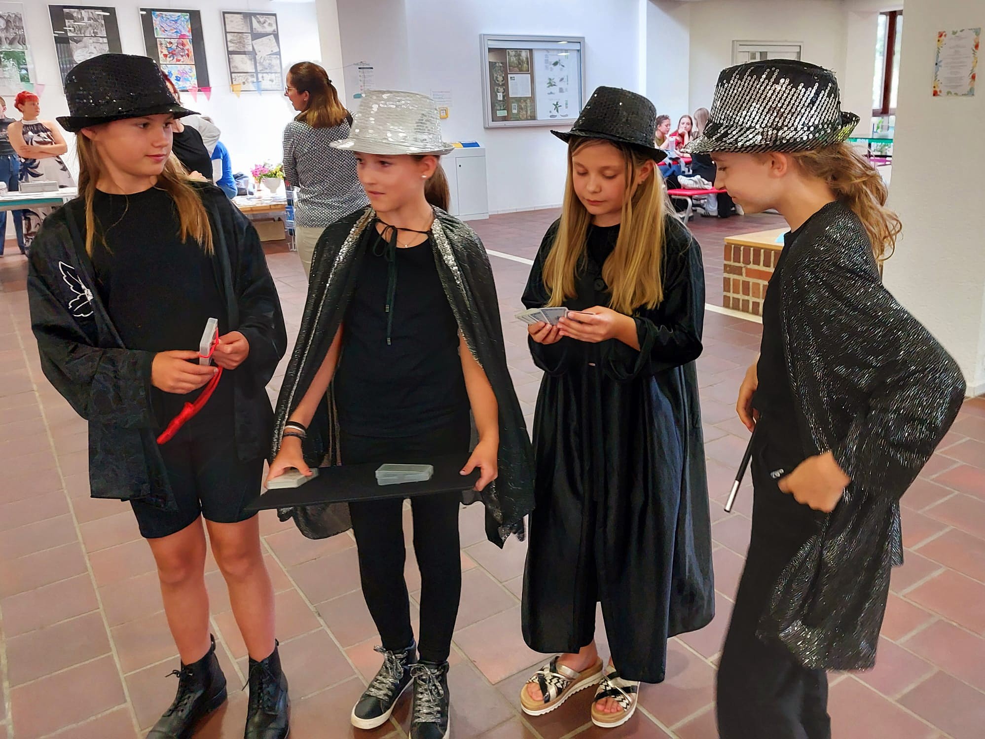 Zauberkurs: Kinder mit Zylinderhut und Umhang zeigen Kartentricks